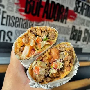 a hand holding a burrito