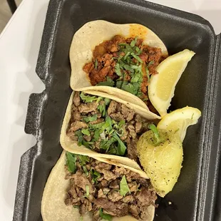 two tacos in a black container