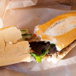 grilled pork banh mi (torn in half to show inside)