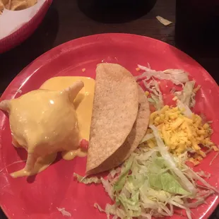 Queso poured on the outside of the small taco bowl and a beef taco