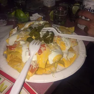 a plate of nachos with a fork and knife