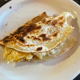 Baliadas (Honduras) composed of a flour tortilla, filled with a smear of mashed &quot;refried&quot; red beans, crema, and crumbled queso duro.