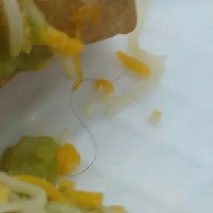 Cheese guacamole and a long black curly hair :( disgusting