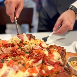 a person cutting a pizza