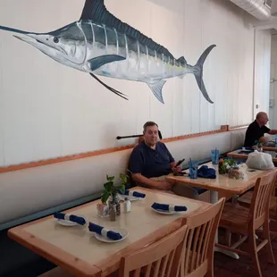 A long banquette in the back with more handsome decor - my spouse (and a beautiful Marlin).