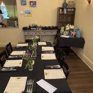 One of the 5 tables with our handpicked wild flowers in small vases and the preset menus. Gift table in background.