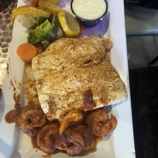 Mahi Mahi with shrimp over a bed of Mexican rice , sautéed mix vegetables and side of queso.
