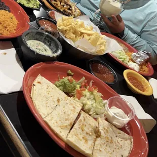 A full table of good food. Piña Coladas, quesadillas, guacamole, rice, all the good stuff.