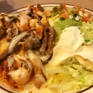 Lunch ACP Texano - Rice, cheese, chicken, steak, shrimp, pico, guac, and sour cream on a bed of lettuce
