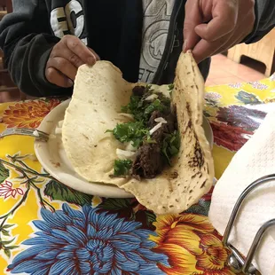 a man holding a tortilla