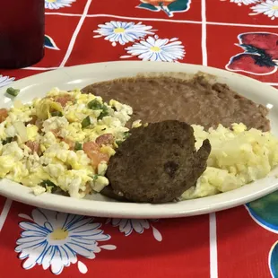 Huevos ala Mexicana with refried beans, soft potatoes, and choice of sausage or bacon