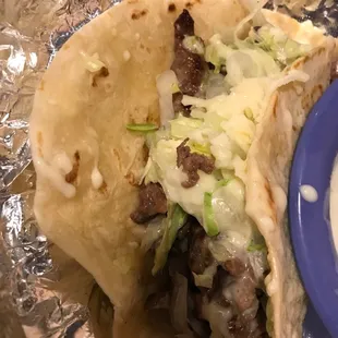 Steak taco with cheese and lettuce