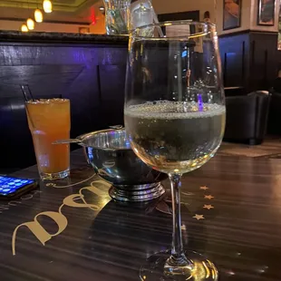 a glass of white wine and a glass of orange juice