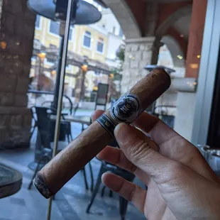 a hand holding a cigar