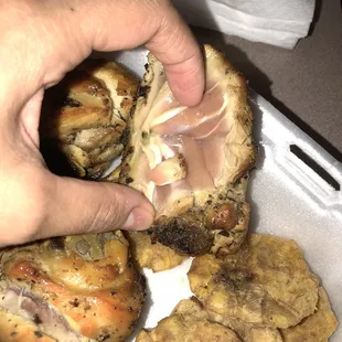 a person grabbing a piece of chicken