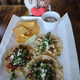 Three tacos plate with fresh tortilla chips and beans
