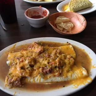 Smothered burrito know as the wet burrito with cheese  also some barbacoa soft tacos and a guac taco