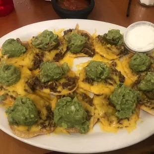 a plate of nachos with guacamole