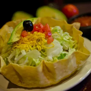 a taco salad with lettuce and tomatoes