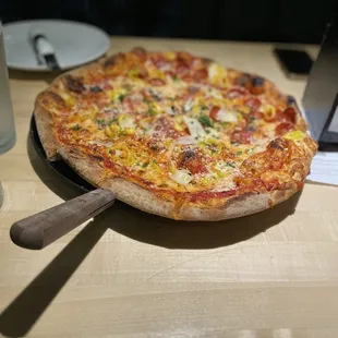 a pizza on a plate with a wooden spatula