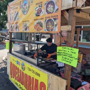 a man preparing food at a food stand