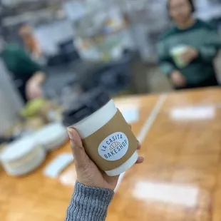 a hand holding a cup of coffee