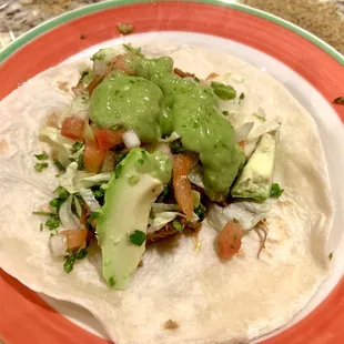 Flour tortilla filled with season shredded pork, sliced avocado, lettuce, cilantro, pico de gallo and topped with avocado sauce.