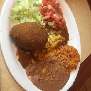 Stuffed fried avocado with cheese enchilada, rice, and refried beans