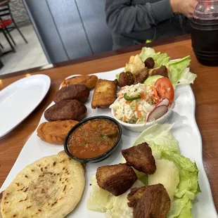 Plato tipico: fried yucca &amp; pork, salad, salsa, 1 tamale , 1 pupusa, 2 empanadas , 2 fried stuff plantains (one bean, one cheese) $29.99