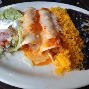 Chicken enchiladas with rice and black beans.