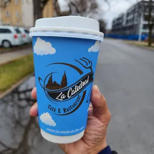 a hand holding a cup of coffee