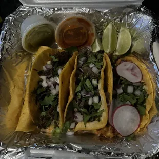 a tray of tacos and salsa