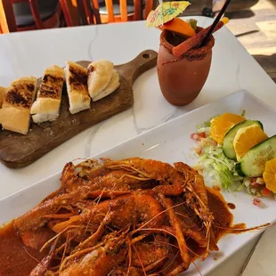 a plate of shrimp and a salad on a table