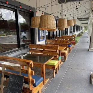 Outdoor tables near the front entrance. There's also a covered patio with more seating.
