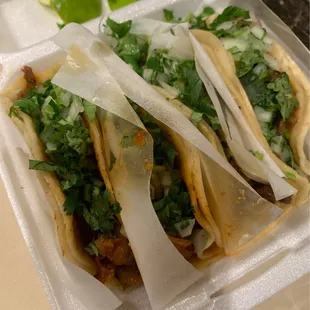 three tacos in a styrofoam container