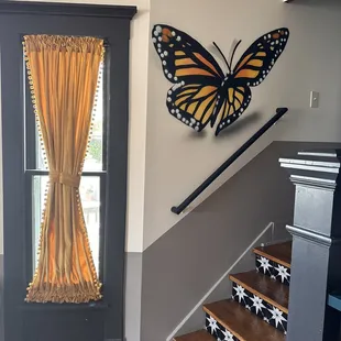 a butterfly on the wall above the stairs