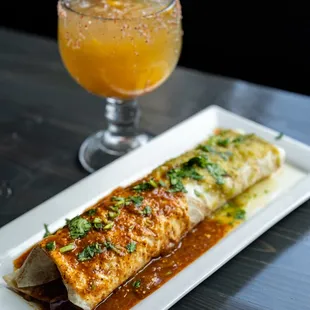 a plate of enchilada and a glass of orange juice