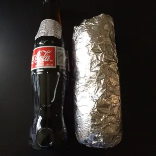 The $8 "Deluxe" Burrito next to a MX Coke bottle for comparison. It used to dwarf the same bottle for $1 less a year or two ago.