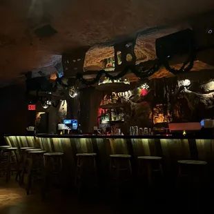 a dimly lit bar with a lot of stools