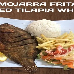 Fried whole tilapia with rice, salad and French fries.