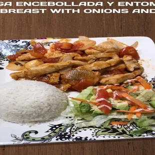 Slices of fried breasts with onion and tomato, rice, salad