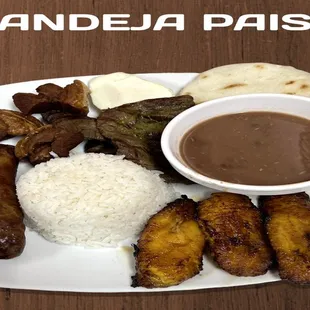 Bandeja paisa with rice, beans, sweet plantains, arepa, pork belly, Colombian sausage, grilled meat, and egg.