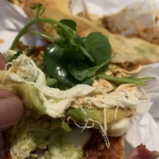 a hand holding a sandwich