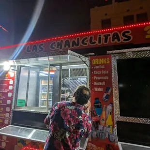 a woman standing in front of a food truck