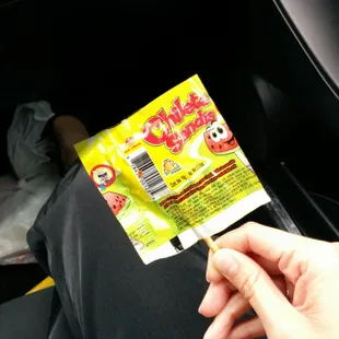 a hand holding a packet of candy