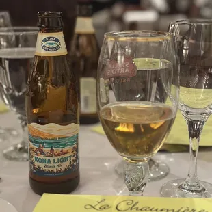 a glass of white wine and a bottle of la chaumiere