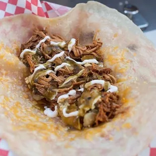 a pulled pork taco in a tortilla basket
