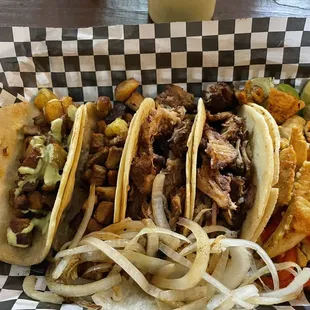 Al pastor (one with mild salsa), carnitas, and chicken fajita tacos with corn tortillas