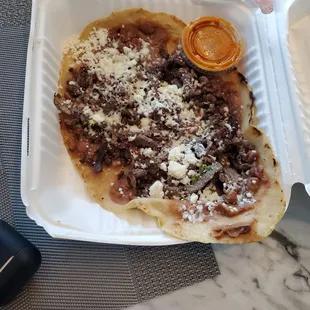 Huarache de carne Corn thick tortilla flour with beans on top, cheese and beef