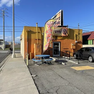 Rear of building, parking lot and tables.